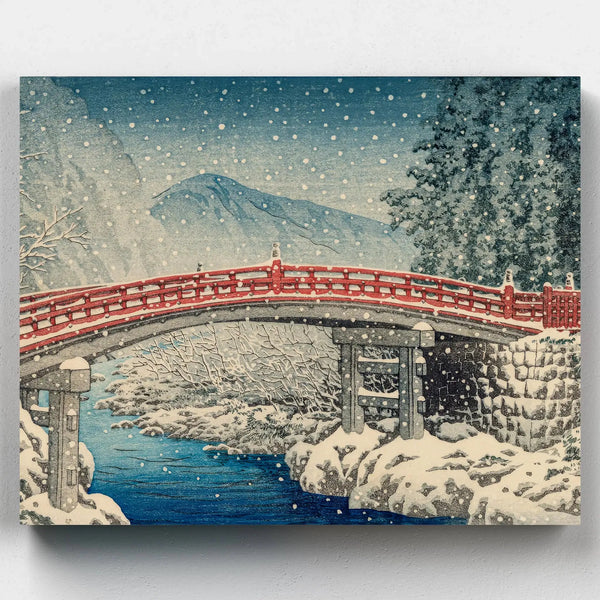 Snow-covered red Japanese bridge over a calm river surrounded by trees and mountains, in a peaceful winter landscape inspired by traditional woodblock style.