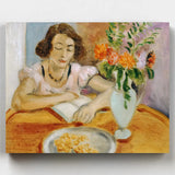 Painting of a woman reading a book with a vase of flowers on a table.