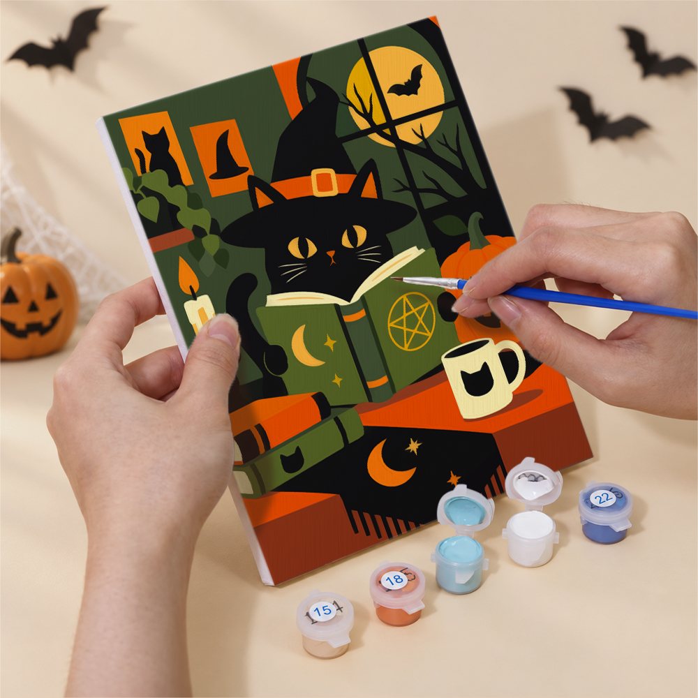 Hands painting a Black Cats & Spellbooks design by numbers