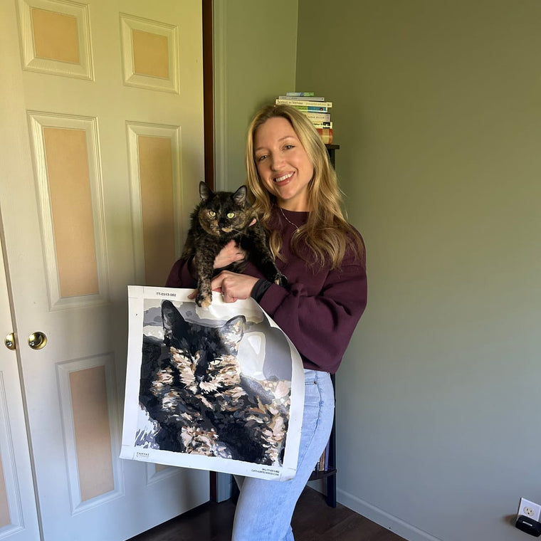 Customer holding her cat and the finished custom paint by numbers painting of it