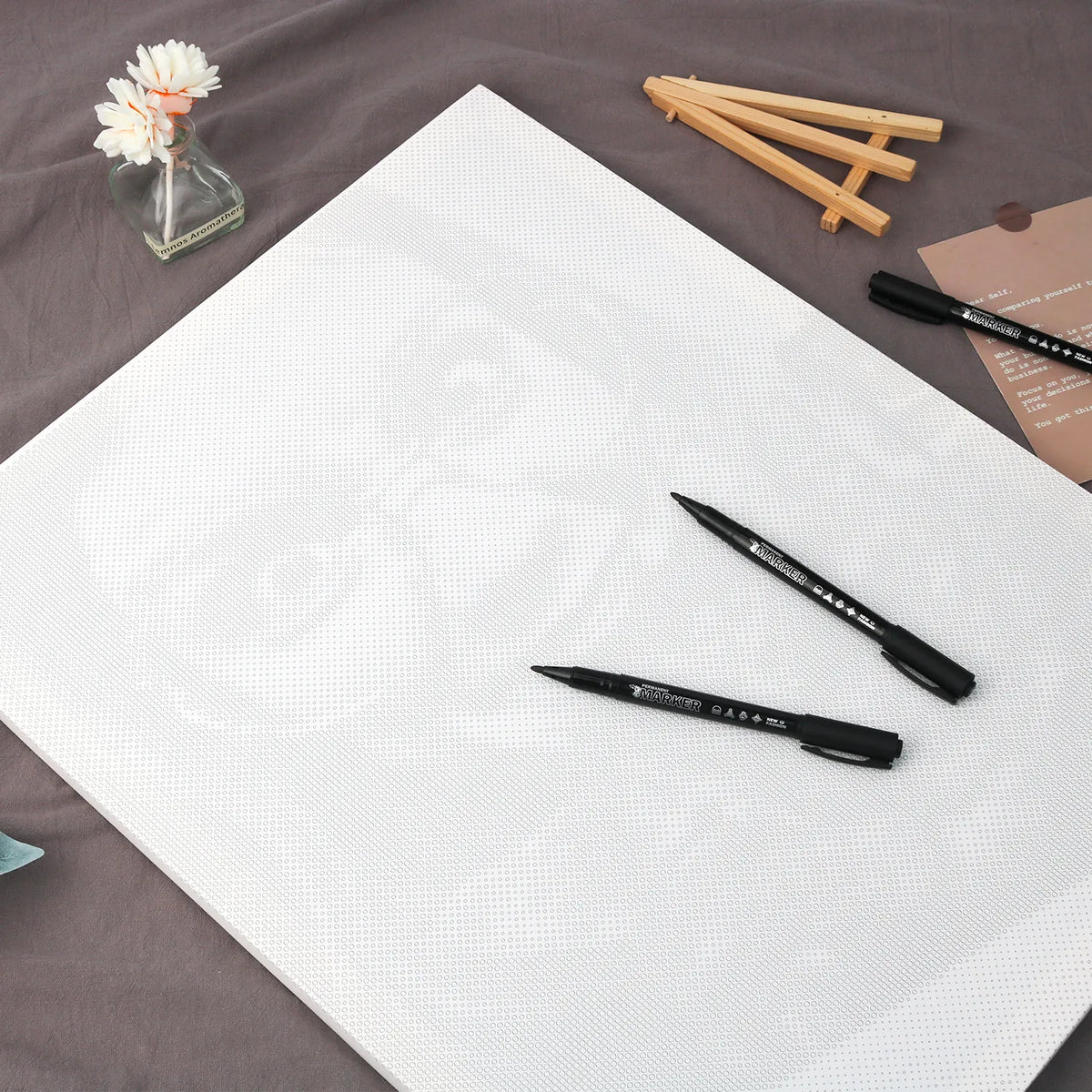 Blank dot-printed canvas with markers, ready to personalize