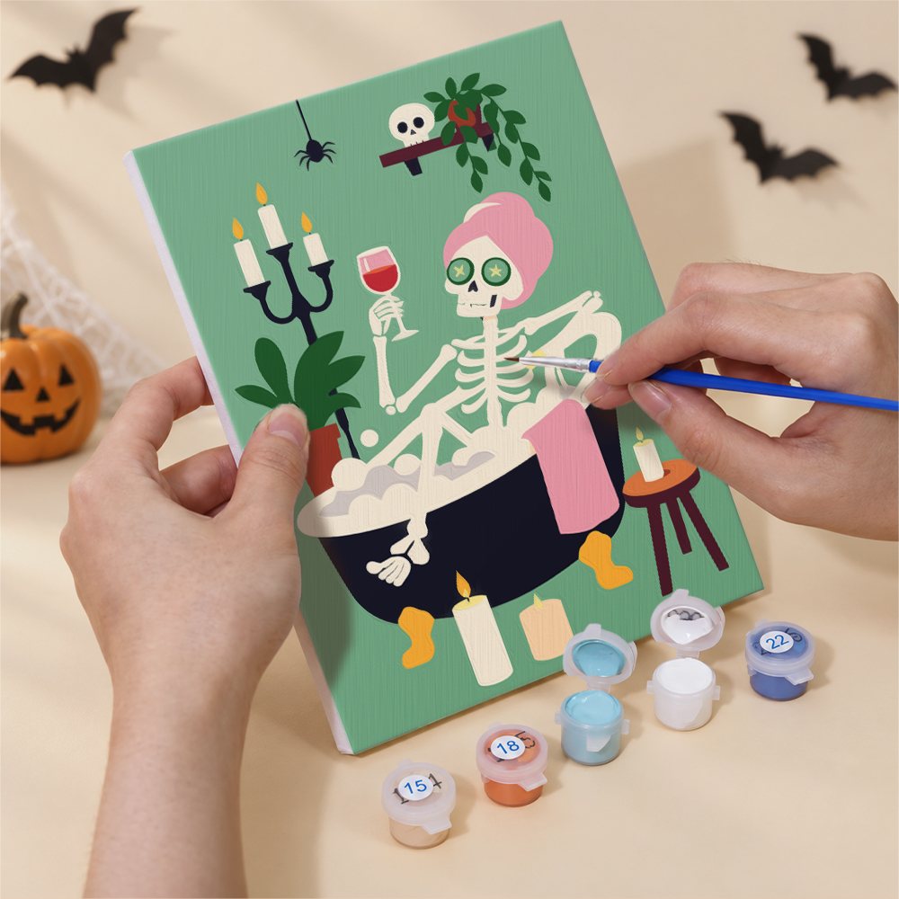 Hands painting a Fireside Fall Spooks design by numbers