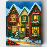 Cozy Christmas house paint by numbers kit featuring a warmly lit brick home decorated with wreaths, garlands, and snow-covered greenery in a festive winter setting.