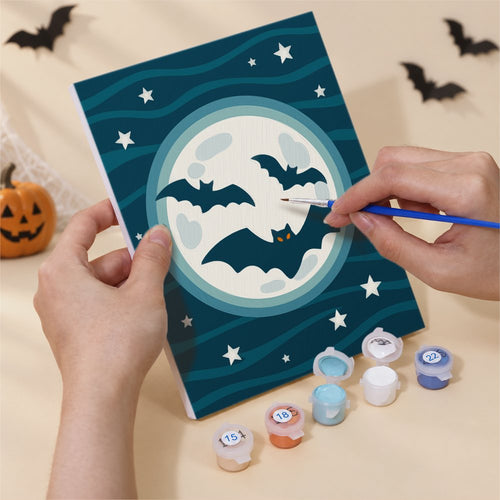 Hands painting a Teal & Tangerine Halloween design by numbers