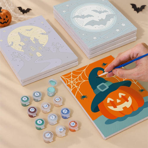 Blank numbered Teal & Tangerine Halloween canvases next to acrylic paint pots